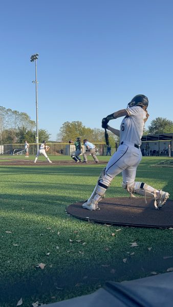 Olivia Hartupee practices her swings as Gracie Mann is up at bat.