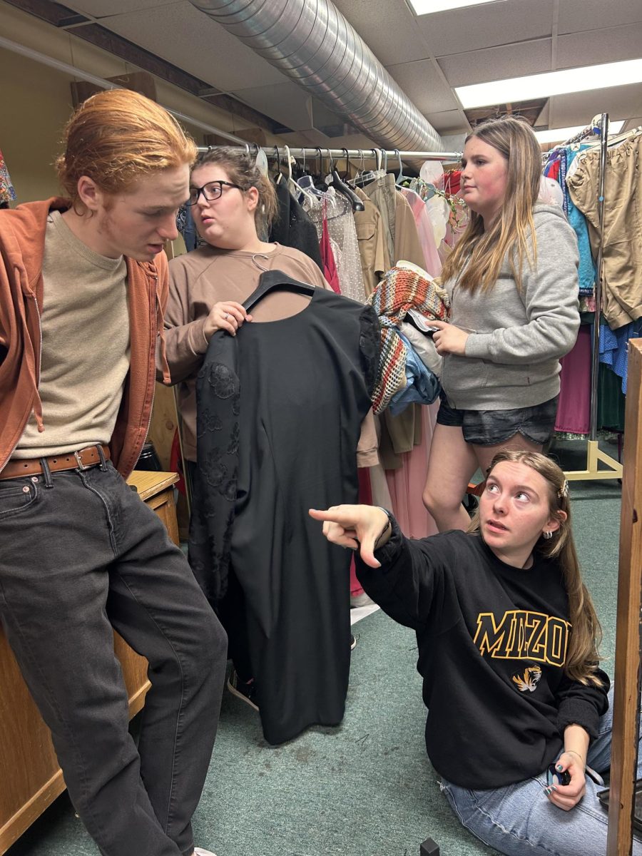 Finnly Blue (lower right) helps student Andrew Russell, Akasha Biesemeyer, and Aubree Wallace with their costumes.