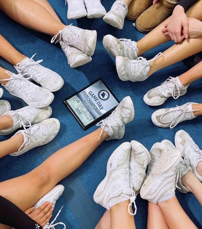 The cheerleaders all sit around their 4th place plaque, after it was announced they won.