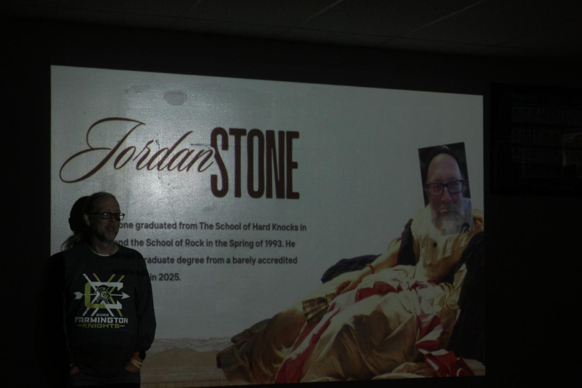 Mr. Stone poses for a picture before a flattering introductory slide of himself.